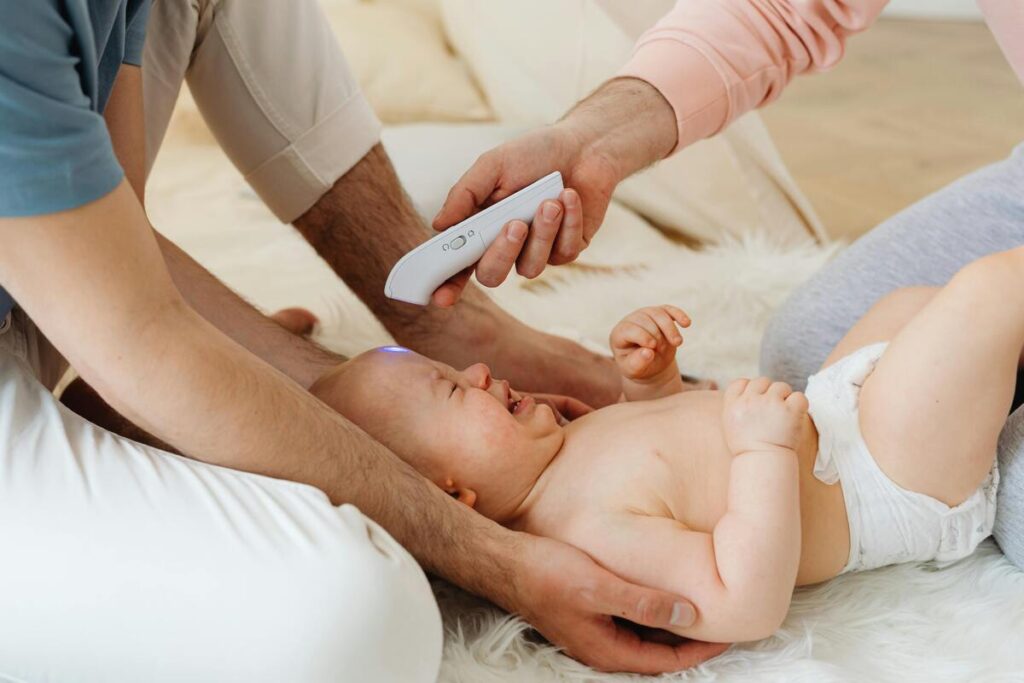 Roditelji mjere temperaturu djetetu koje plače.