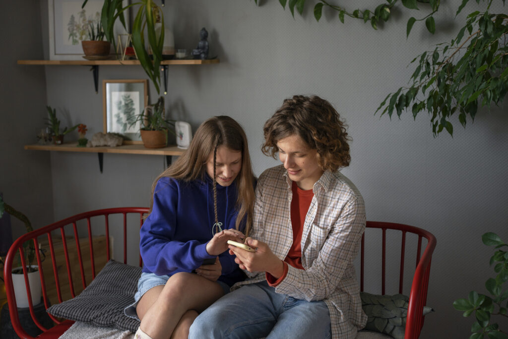 Tinejdžerica i majka gledaju sadržaj na mobitelu