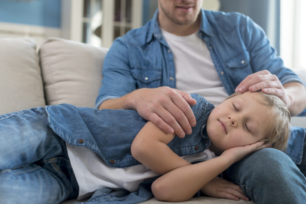 Dječak spava ocu u krilu