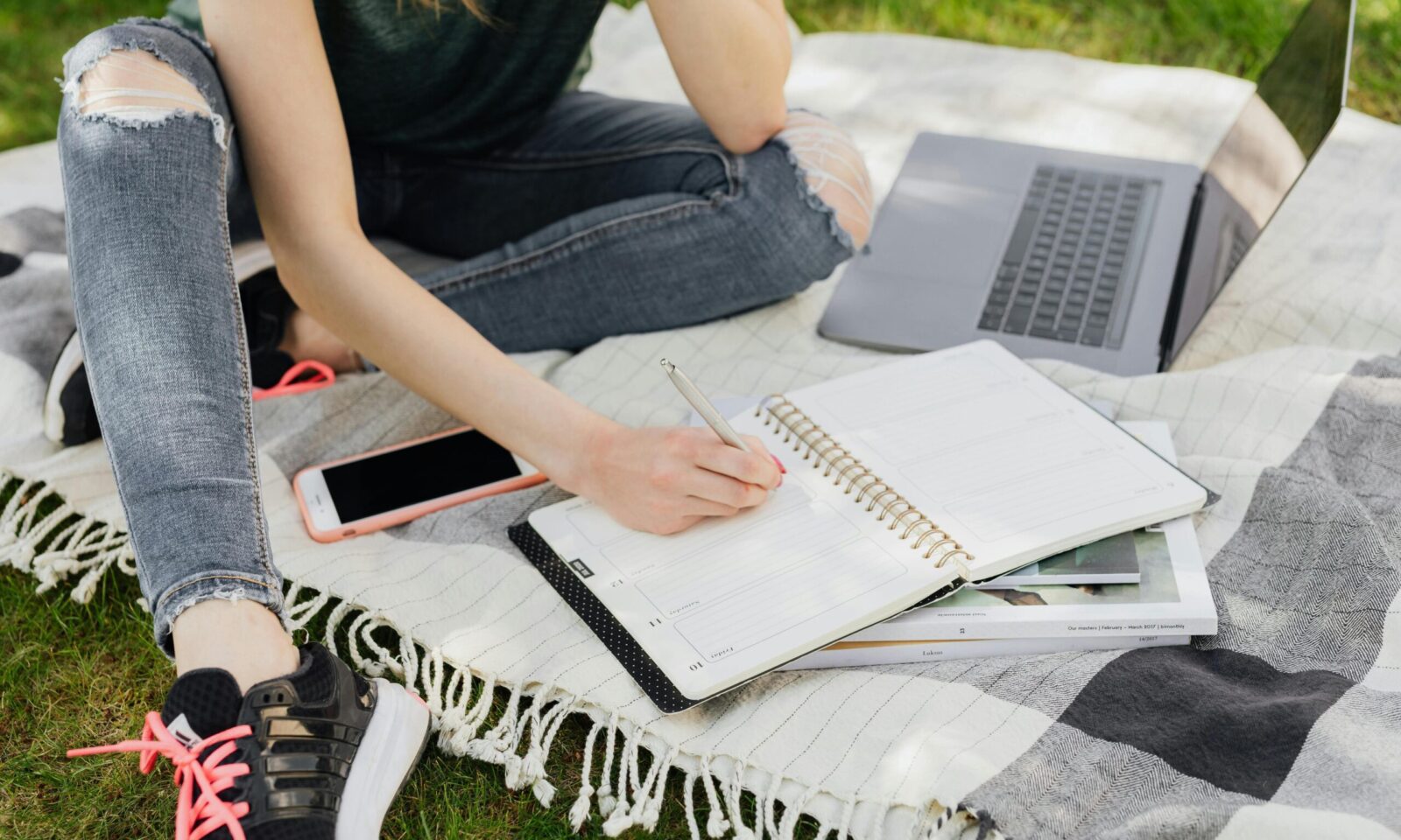 Tinejdžerica koristi laptop i bilježnicu za planiranje