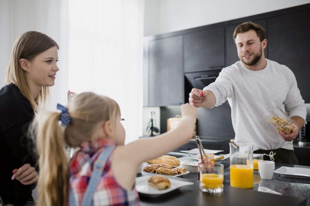 Obitelj okupljena na doručku u kuhinji