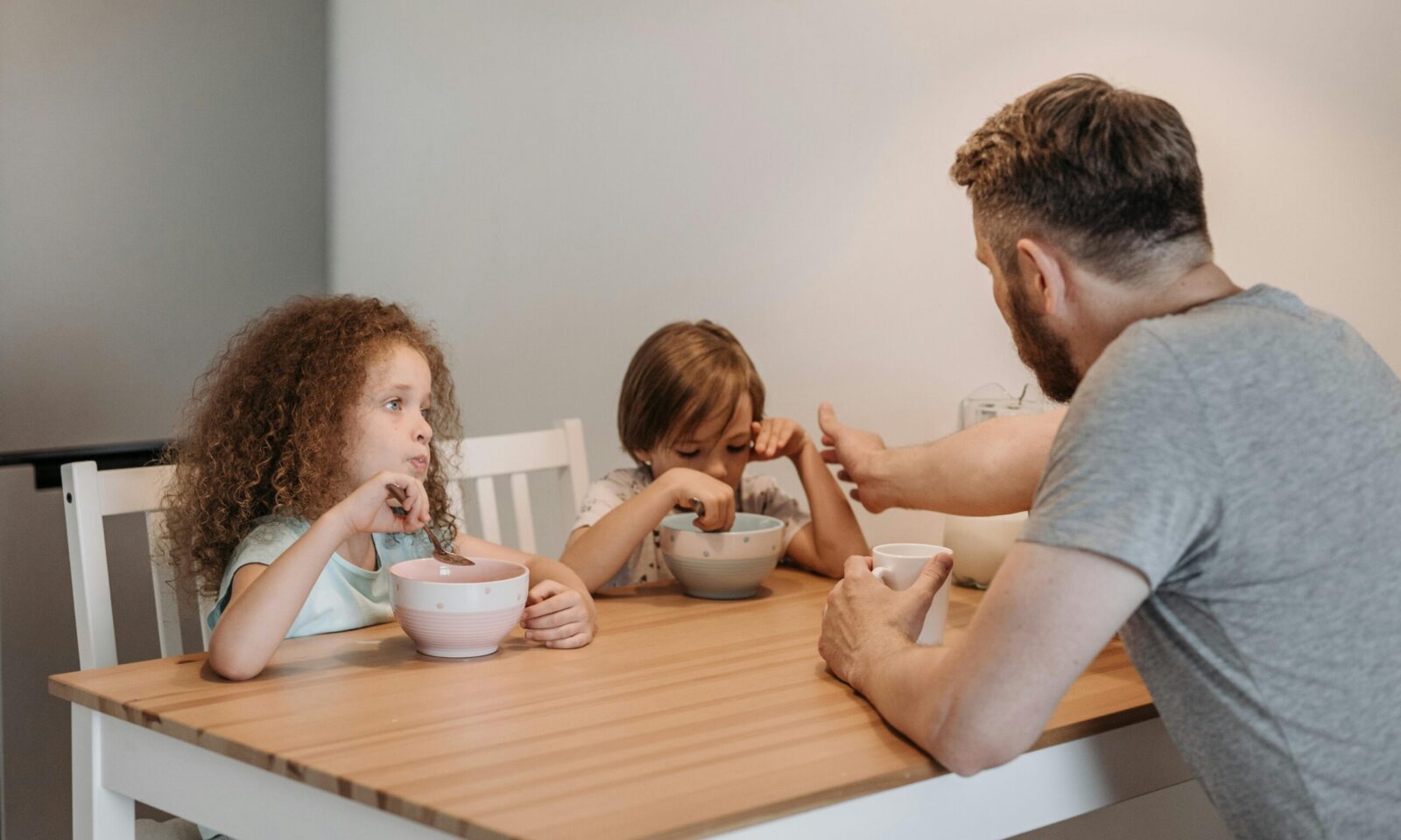Otac razgovara s djecom za stolom