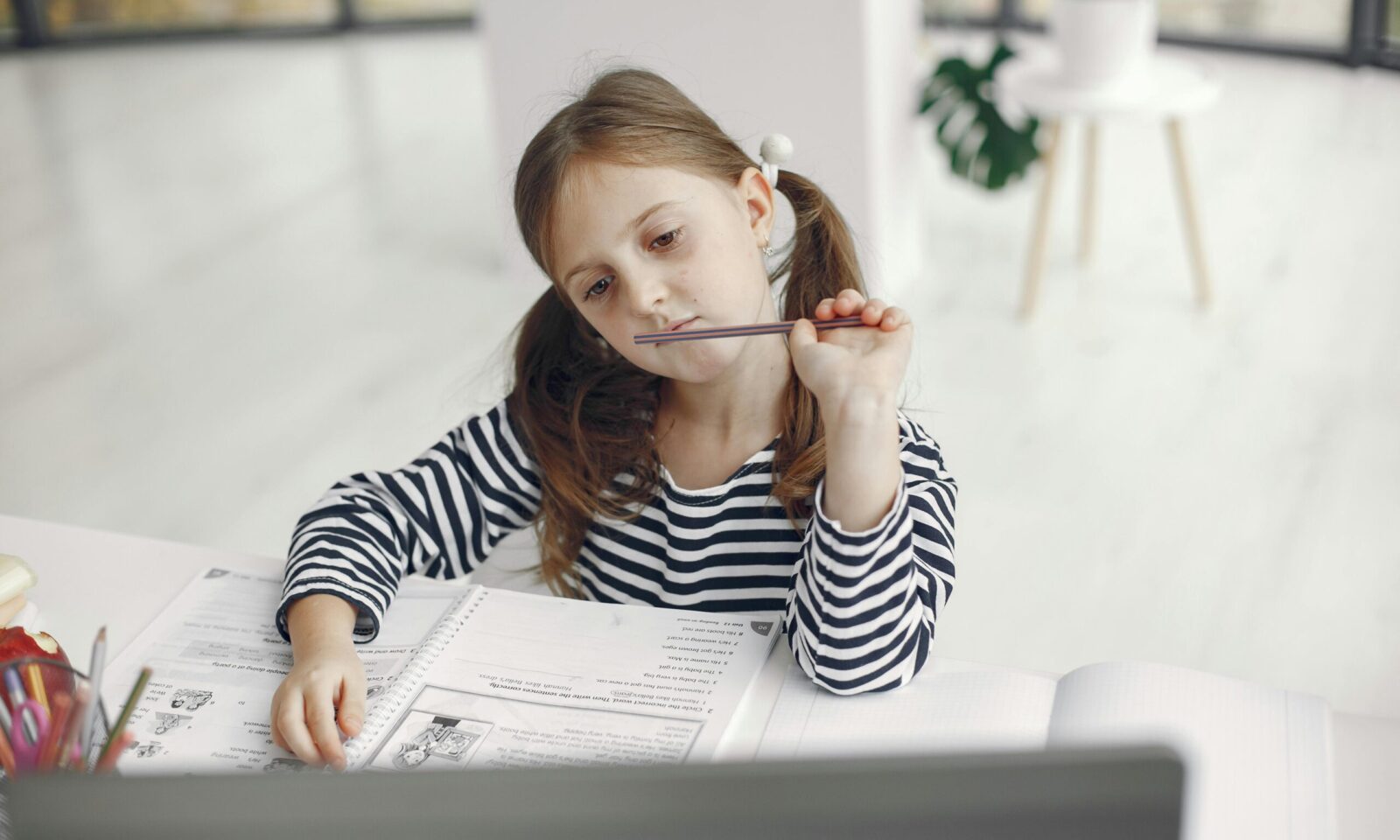 Djevojčica s knjigama i laptopom uči