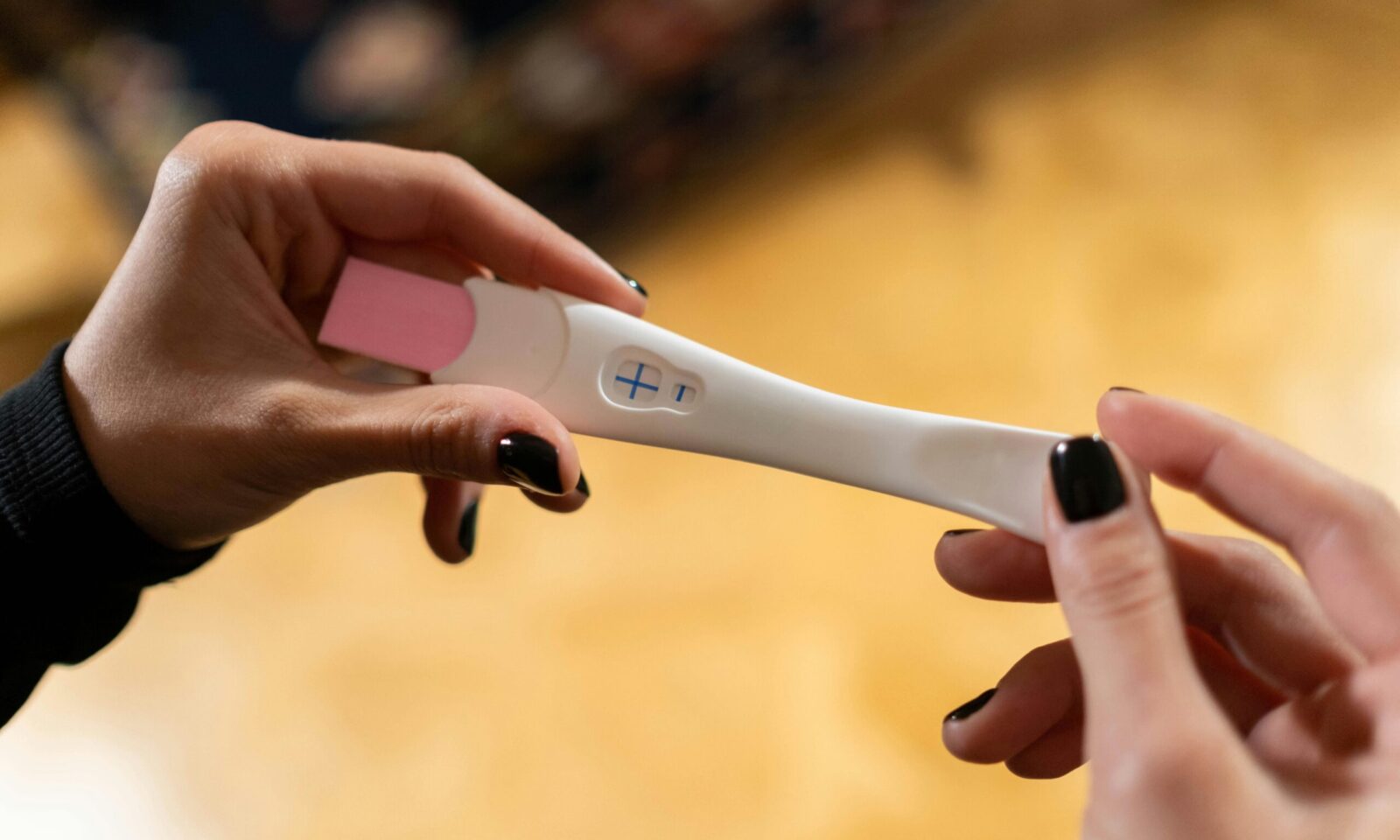 Žena drži pozitivan test na trudnoću