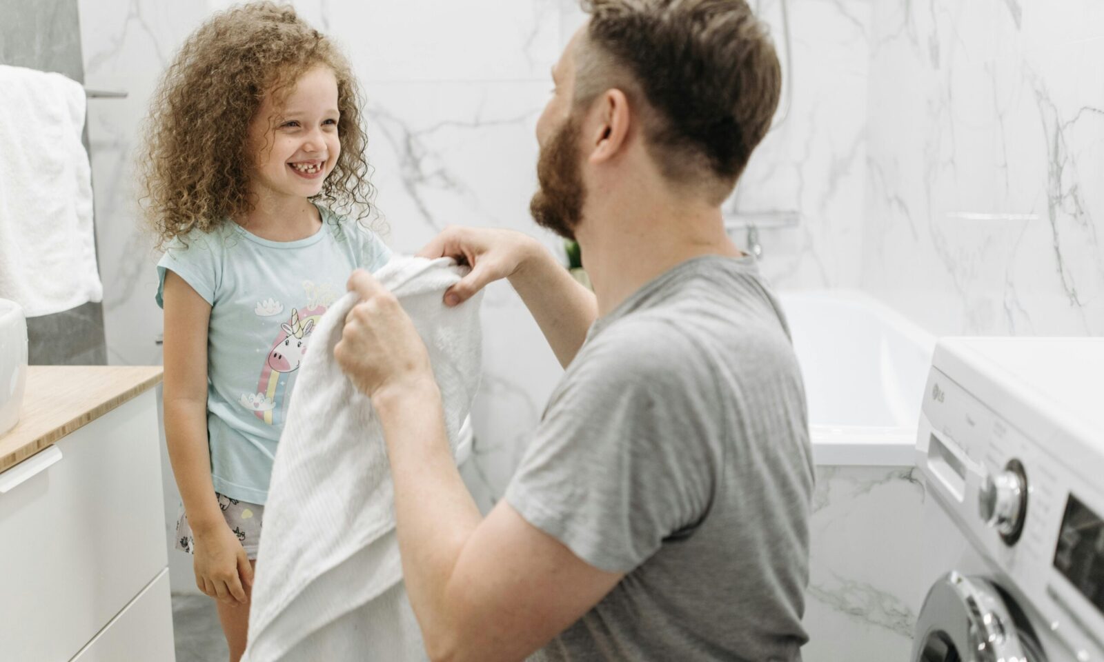 Otac i kći pospremaju odjeću iz perilice rublja
