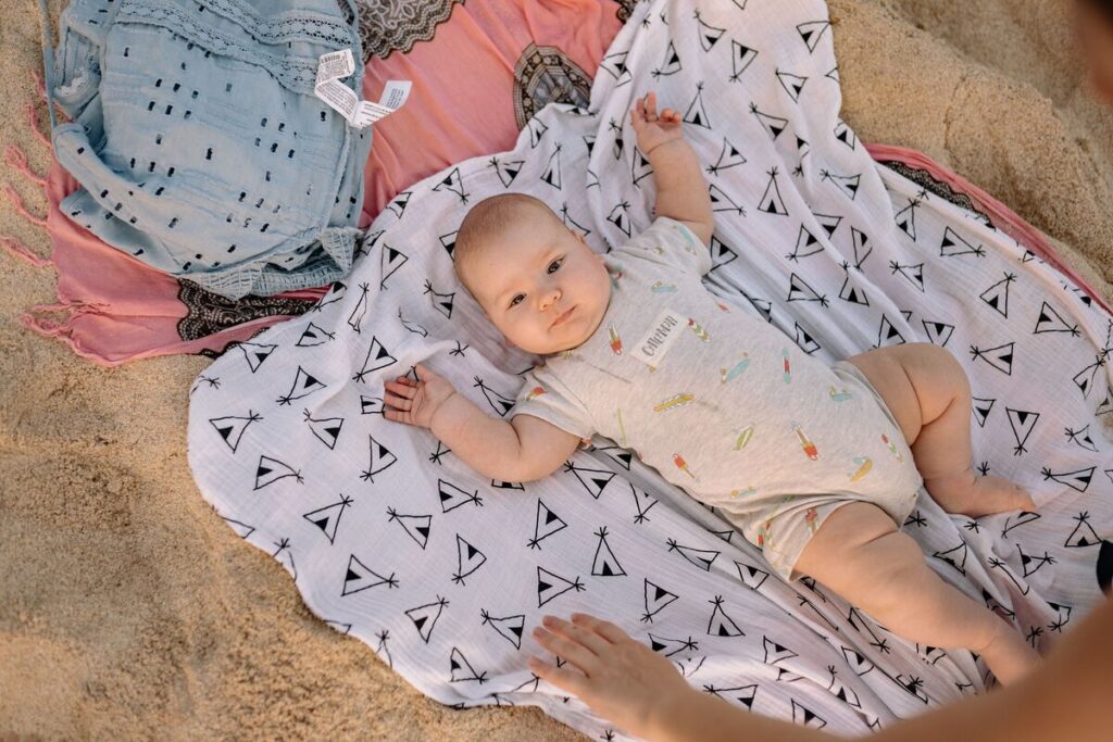 Roditelji presvlače bebu na plaži