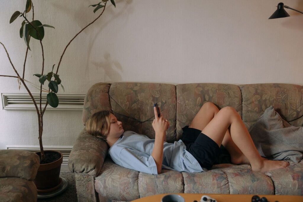 Tinejdžer na kauču gleda u mobitel