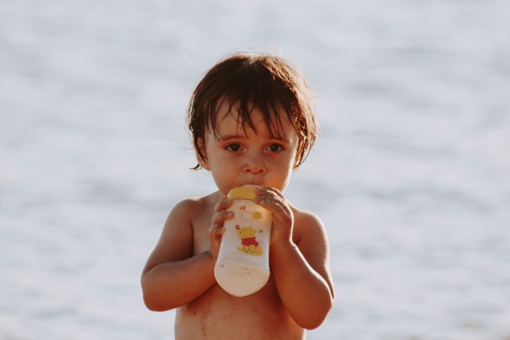 Dječak pije vodu na plaži