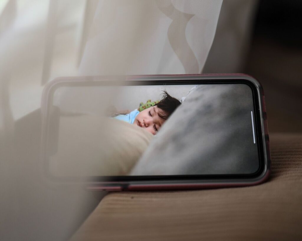 Roditelji na monitoru dijete gledaju kako spava