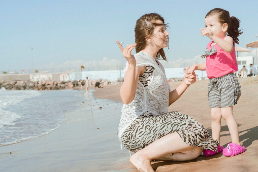 Majka i kći na plaži razgovaraju