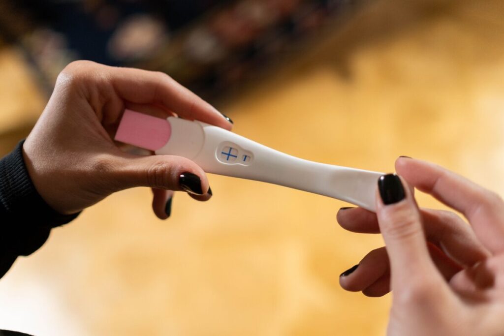 Žena drži pozitivan test na trudnoću