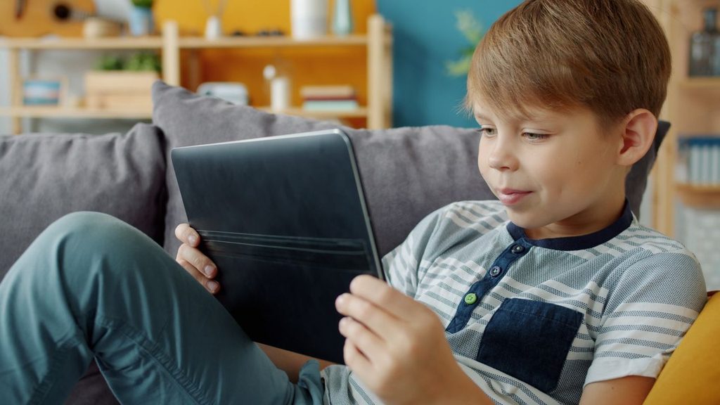 Dječak gleda sadržaj na tabletu